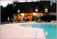 The main building, the entrance, with the illuminated swimming pool of Camping de Poinsouze.